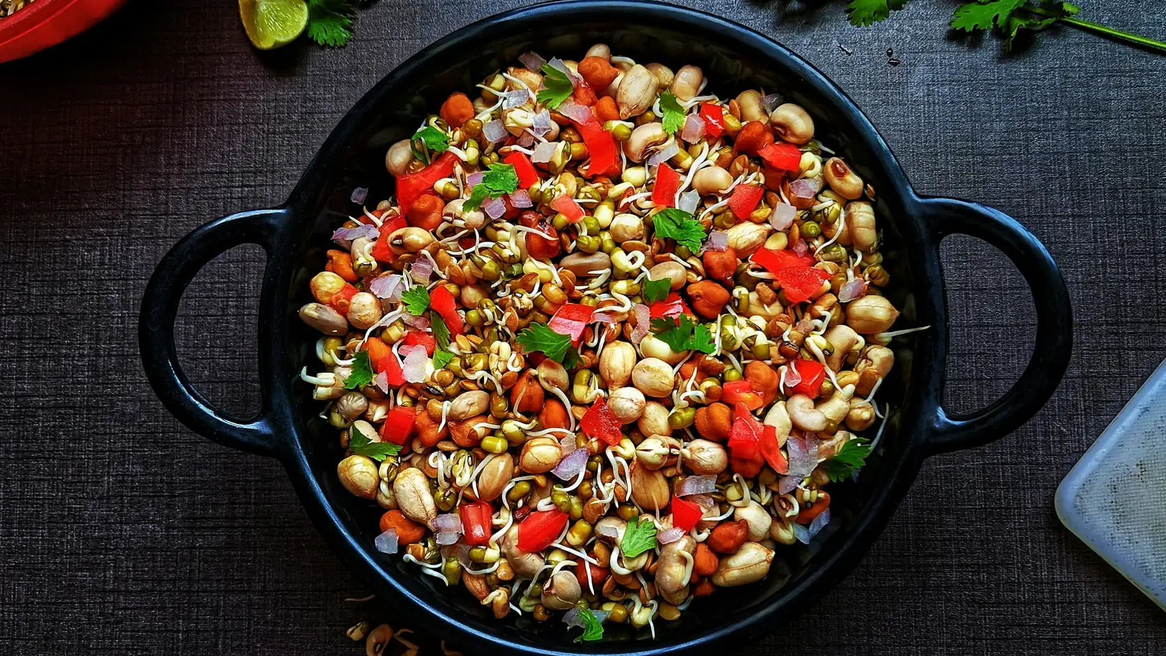 Moong and peanut sprouts chaat with tomato, onion and coriander, a low-calorie high-protein Indian snack.